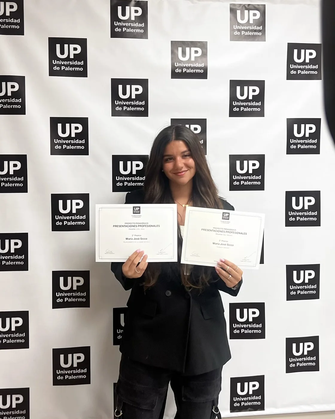 Majo sosteniendo sus dos certificados de «Presentaciones Profesionales»