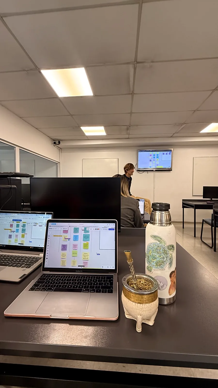 Su puesto en la oficina, con la laptop, el monitor y el mate